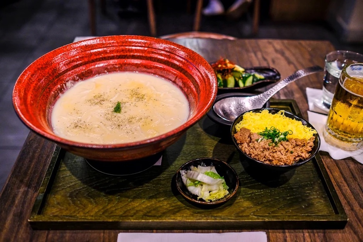 lacquer tray holds red bowl of udon and side dish