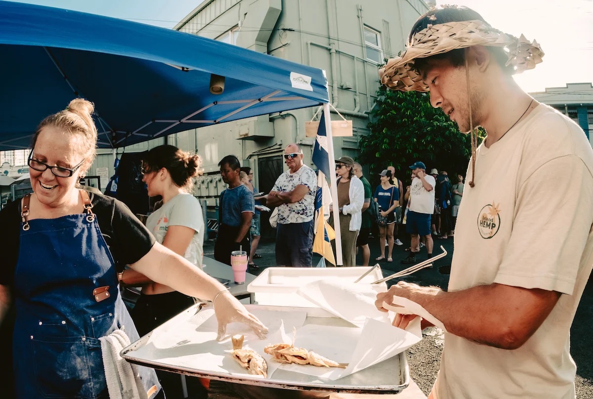 people frying fish in a tent